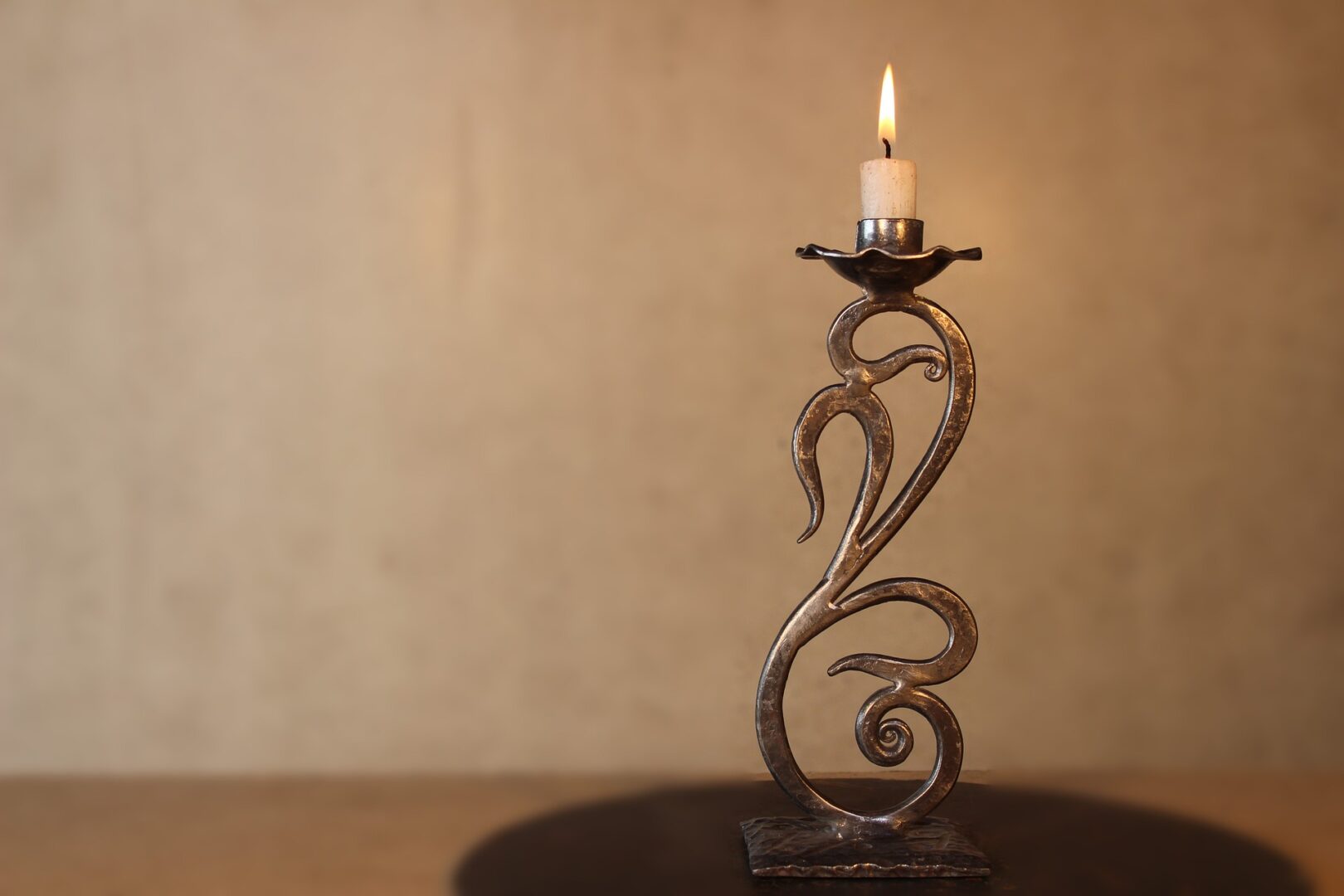 A candle holder with a lit candle on top of it.