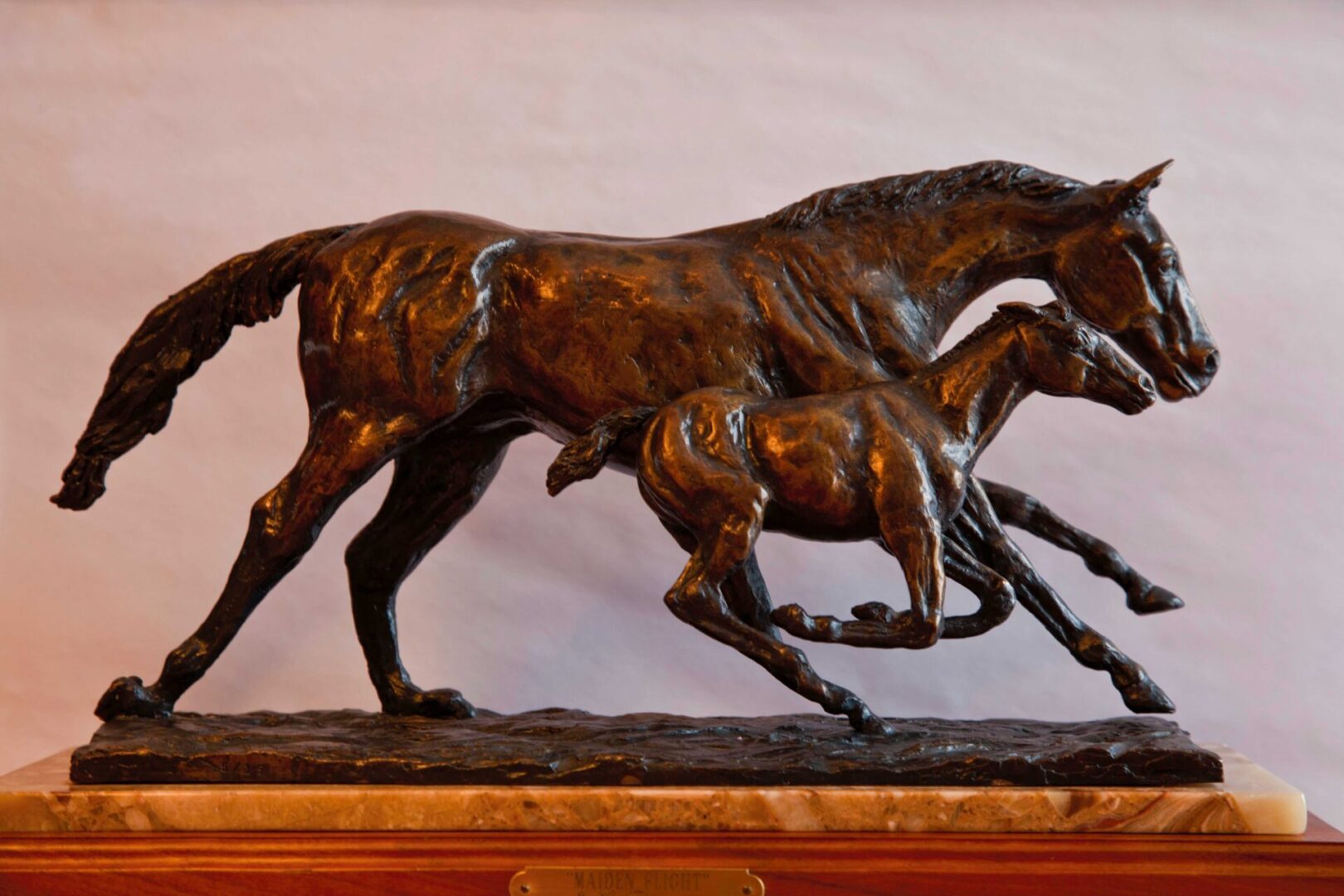 A bronze sculpture of two horses running.