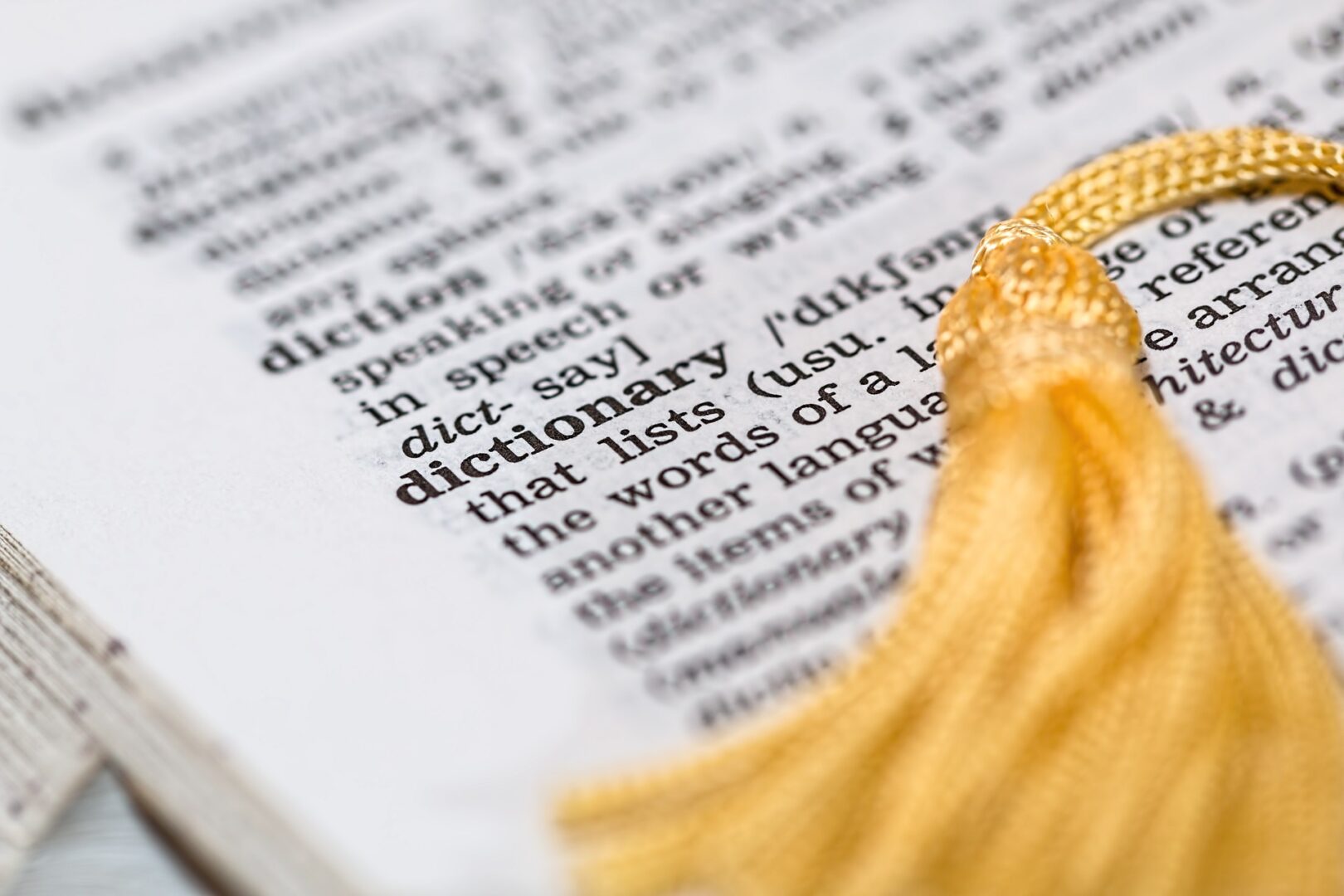 A close up of the word dictionary with a tassel